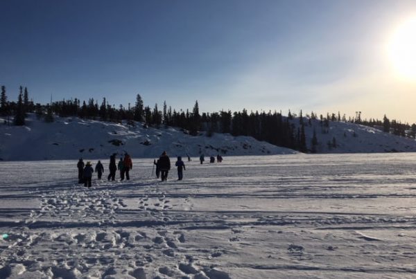 A group of people walking in a snowy field