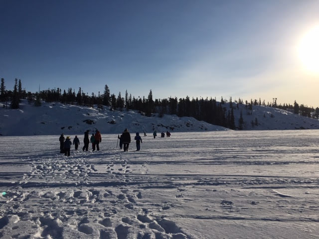 A group of people walking in a snowy field